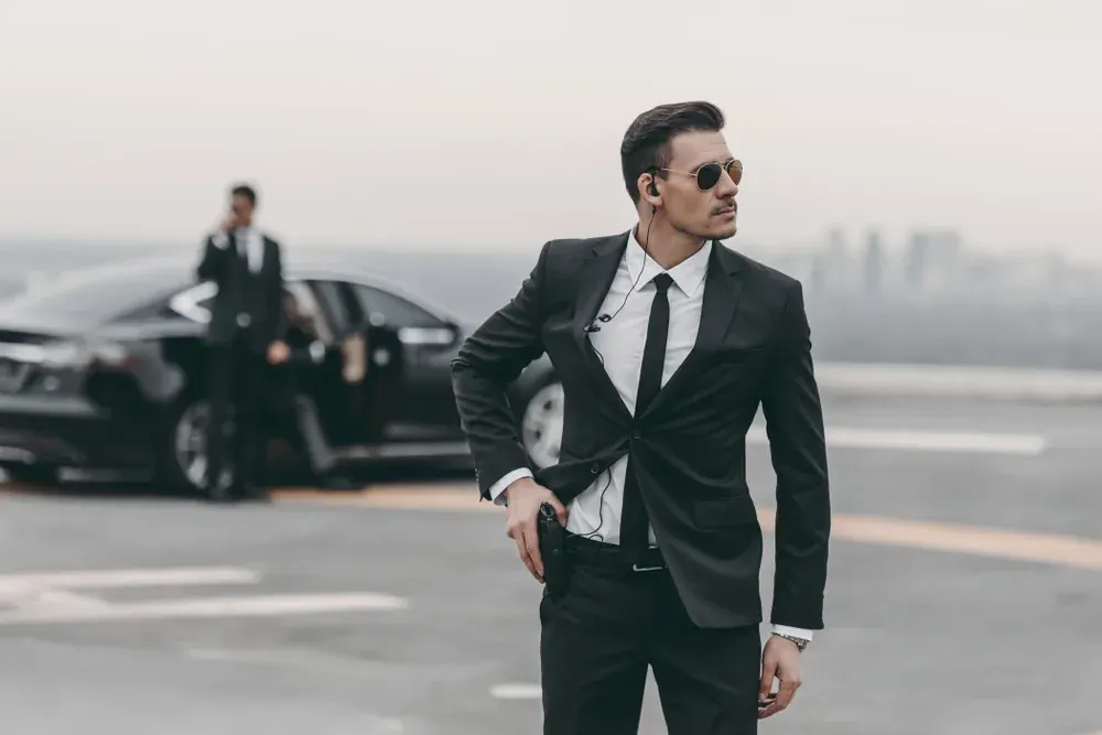 Executive protection professional beside a private vehicle
